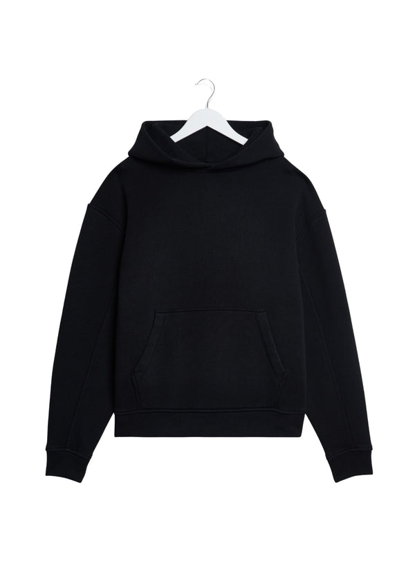 A black pullover hoodie with a front kangaroo pocket, hanging on a white plastic hanger against a plain white background.