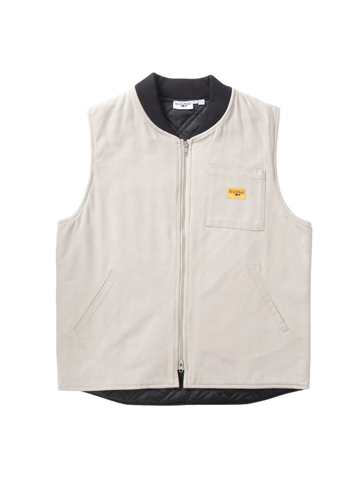 A light beige zip-up vest with a black collar, hem, and inner lining, featuring a small yellow logo patch on the left chest pocket.